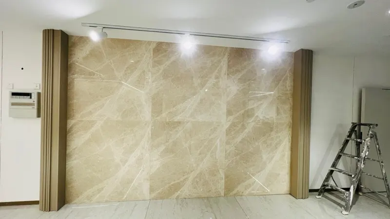Large-format crema marble wall panels with matched veining